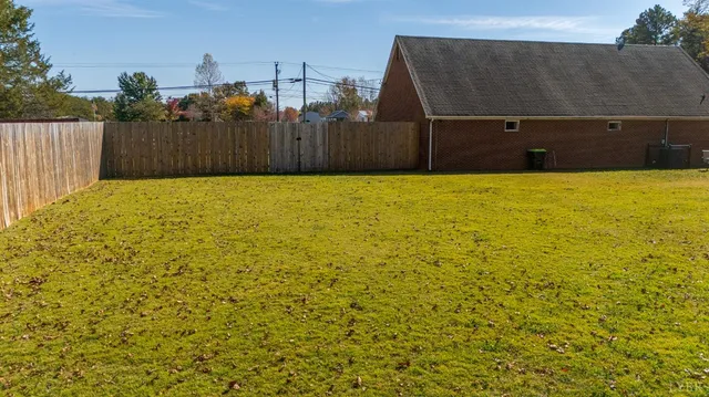 a view of a backyard with wooden fence