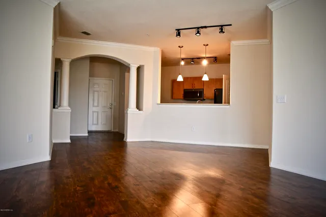 a view of a hallway with wooden floor and glass door