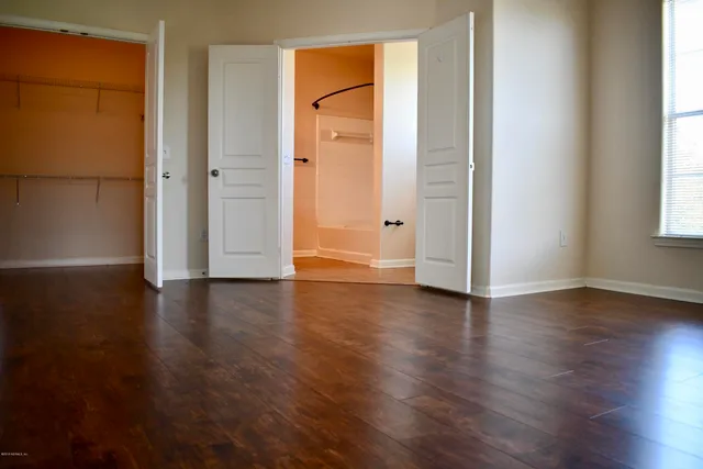 an empty room with wooden floor and a window