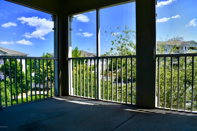 a view of balcony with floor to ceiling windows yard and city view