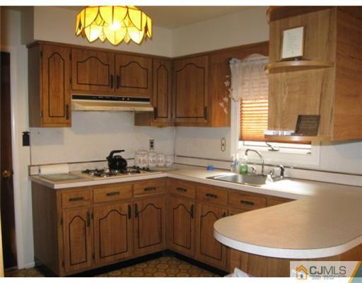 210 Bar Harbor Road Freehold, NJ 07728 - Photo 3 of 9 a kitchen with stainless steel appliances granite countertop a sink a stove and a wooden cabinets
