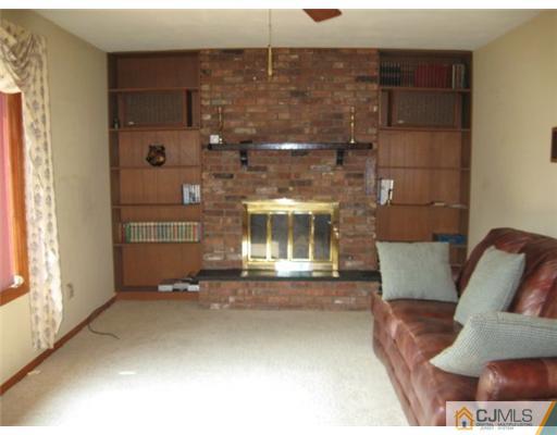 210 Bar Harbor Road Freehold, NJ 07728 - Photo 4 of 9 a living room with furniture and a fireplace