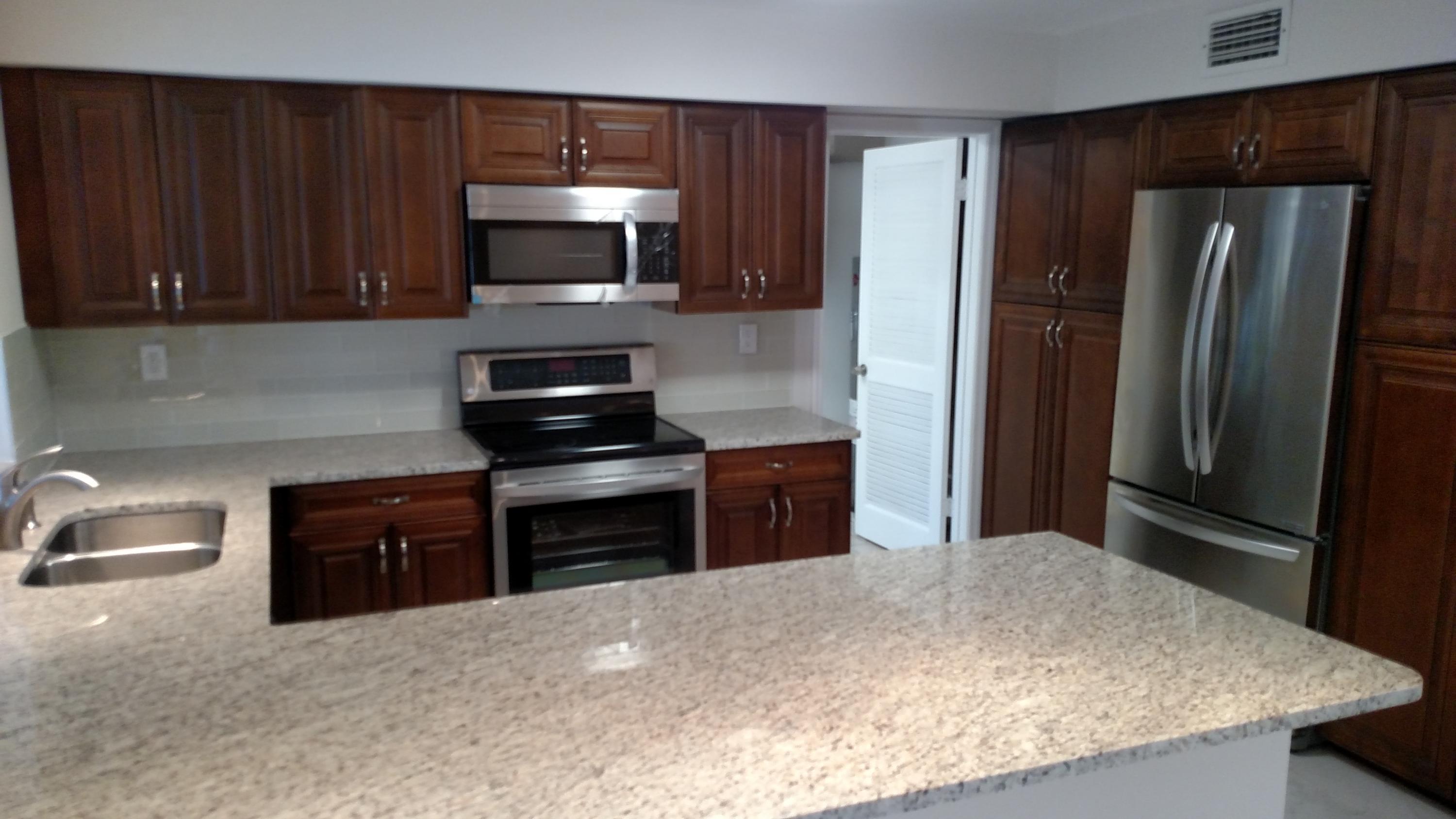 451 West Conference Drive Boca Raton, FL 33486 - Photo 3 of 6 a kitchen with a refrigerator stove and microwave