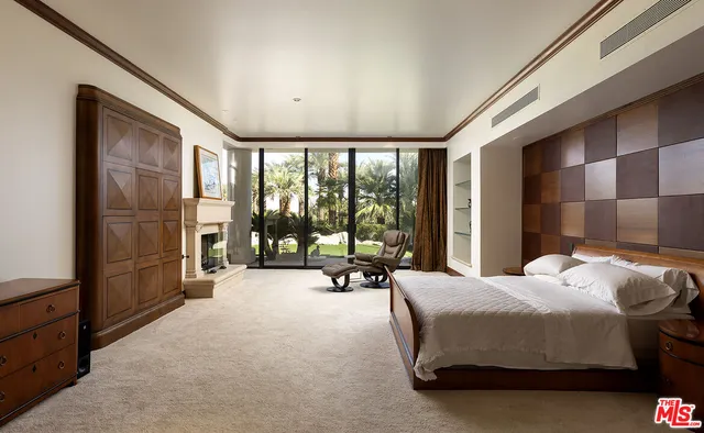 a bedroom with a bed and large windows