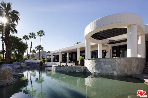 a view of a house with pool and chairs