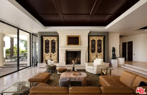 a living room with furniture fireplace and a large window