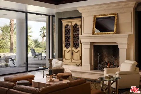 a living room with furniture a fireplace and a floor to ceiling window