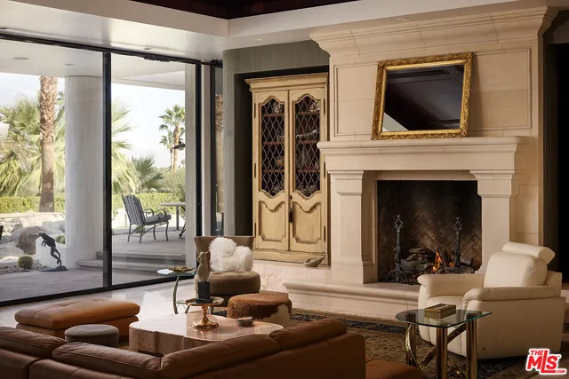 a living room with furniture a fireplace and a floor to ceiling window