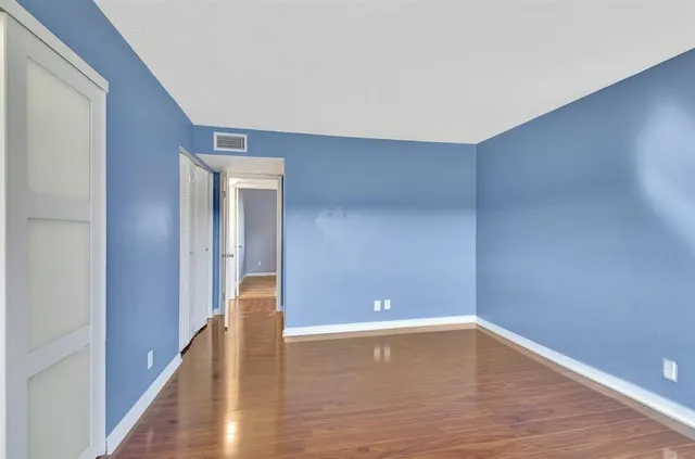 a view of an empty room with wooden floor