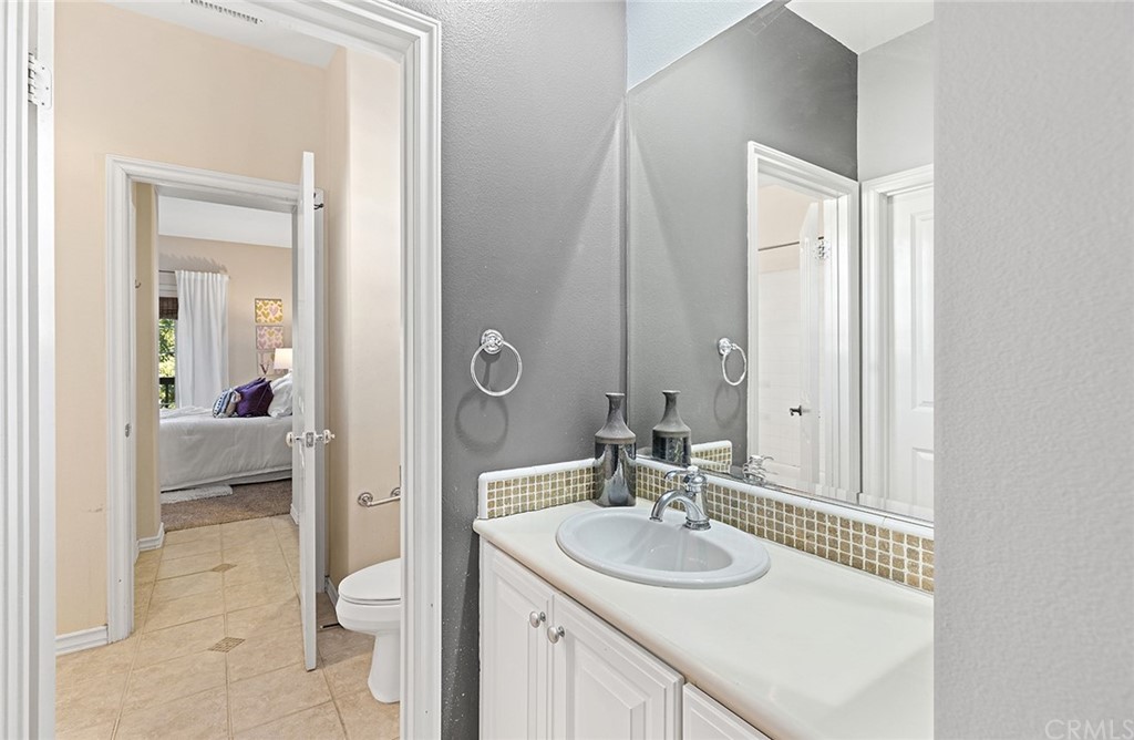 10464 Caribou Way Tustin, CA 92782 - Photo 18 of 34 a en suite bathroom with a sink a toilet and a large mirror