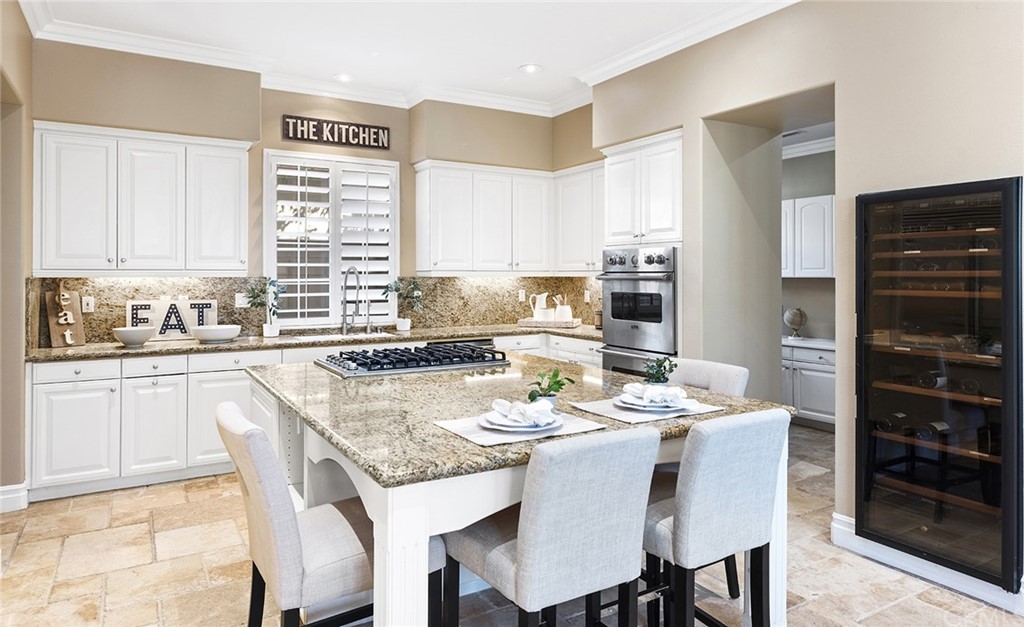 10464 Caribou Way Tustin, CA 92782 - Photo 8 of 34 a kitchen with a dining table chairs and white appliances