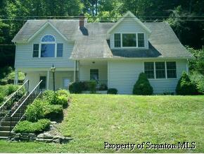 a front view of a house with a yard and potted plants