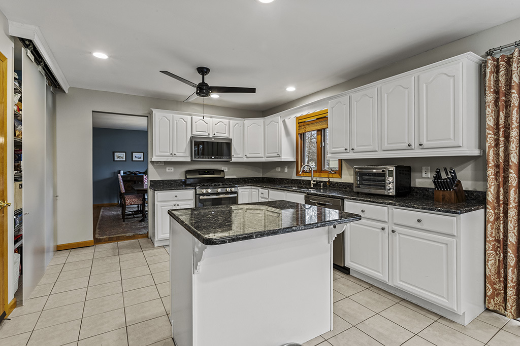 12401 68th Court Palos Heights, IL 60463 - Photo 6 of 24 a kitchen with granite countertop a sink a counter top space appliances and cabinets