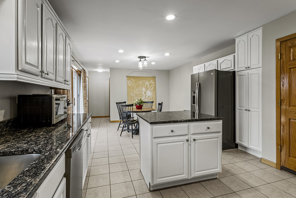 12401 68th Court Palos Heights, IL 60463 - Photo 7 of 24 a kitchen with stainless steel appliances kitchen island granite countertop a refrigerator and a stove top oven