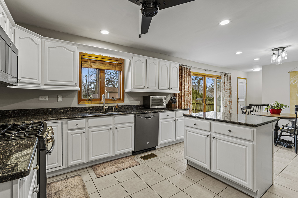 12401 68th Court Palos Heights, IL 60463 - Photo 8 of 24 a kitchen with granite countertop white cabinets white appliances a sink and a window