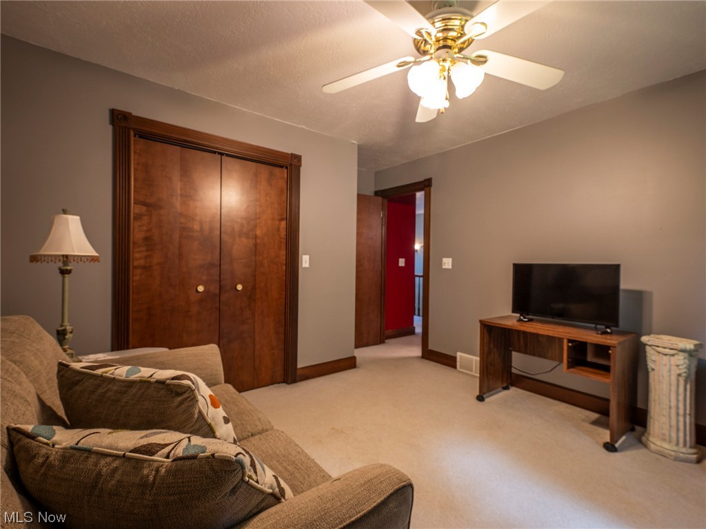 9452 Pleasant Hill Road Northwest Dundee, OH 44624 - Photo 25 of 35 Carpeted living room with ceiling fan