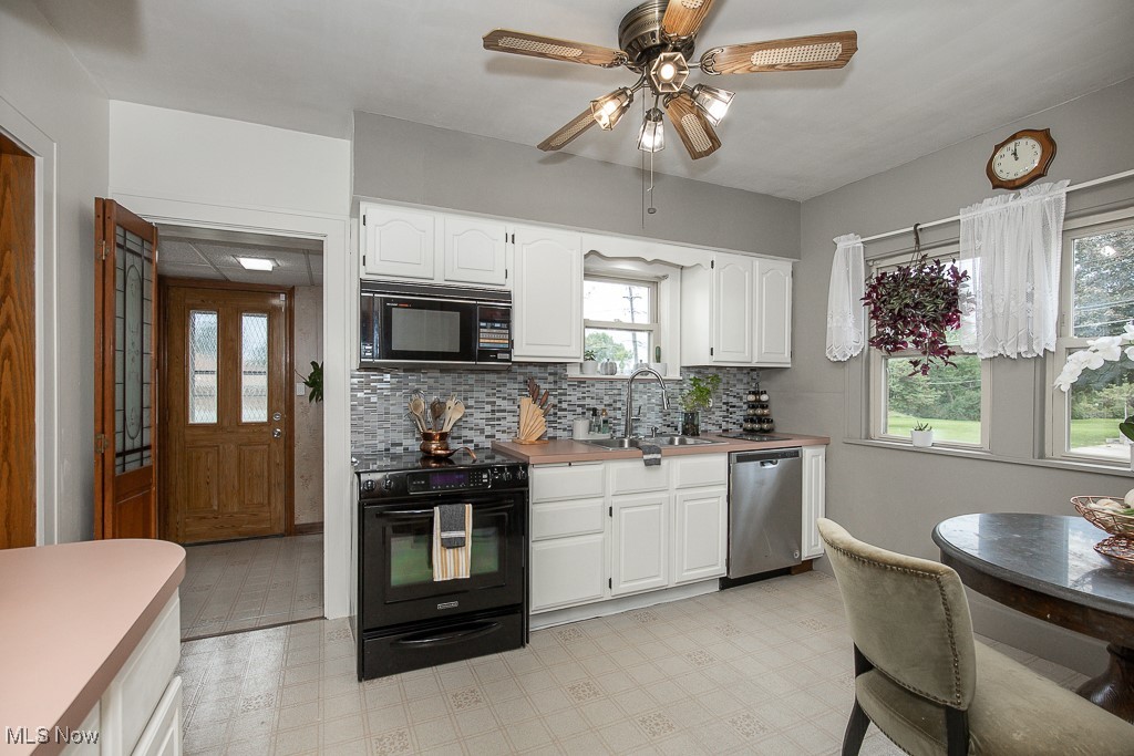 7070 Ridge Road Parma, OH 44129 - Photo 5 of 28 Kitchen with white cabinets, black appliances, a healthy amount of sunlight, and sink