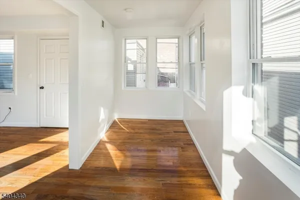 a view of a bedroom with wooden floor and a rug