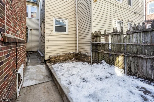 a view of house with wooden floor next to a building