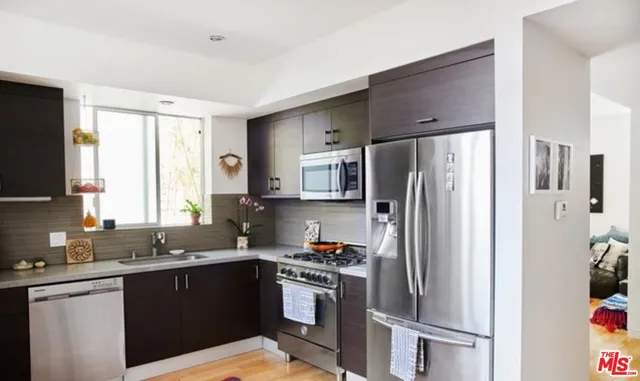 a kitchen with stainless steel appliances granite countertop a refrigerator stove and sink