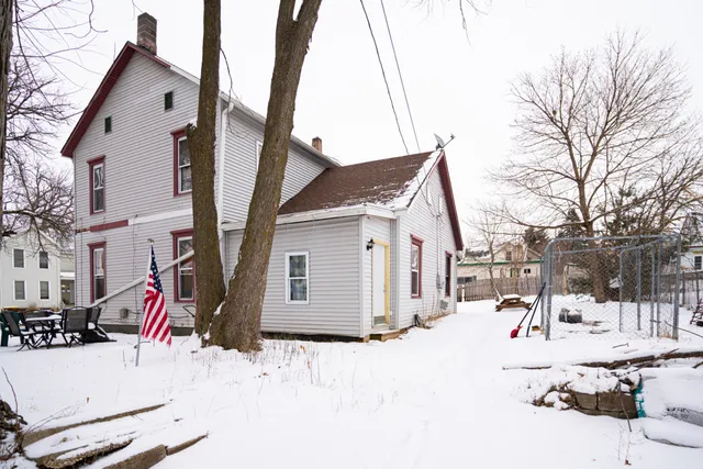 a view of a white house with snow on the road
