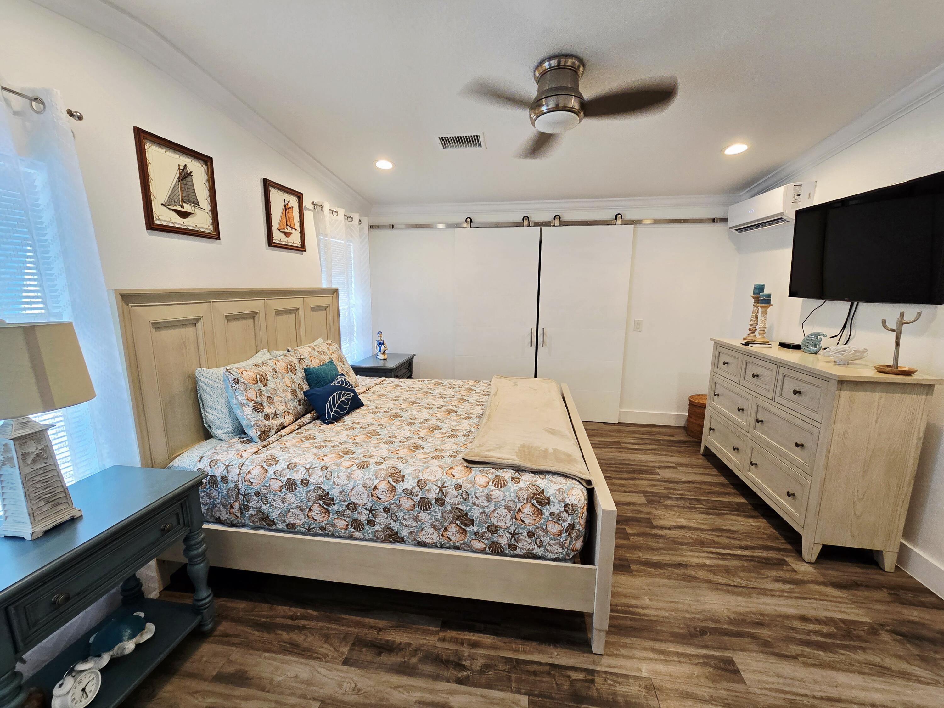 837 91st St Ocean Marathon, FL 33050 - Photo 16 of 27 a bedroom with a bed a flat screen tv and a couch