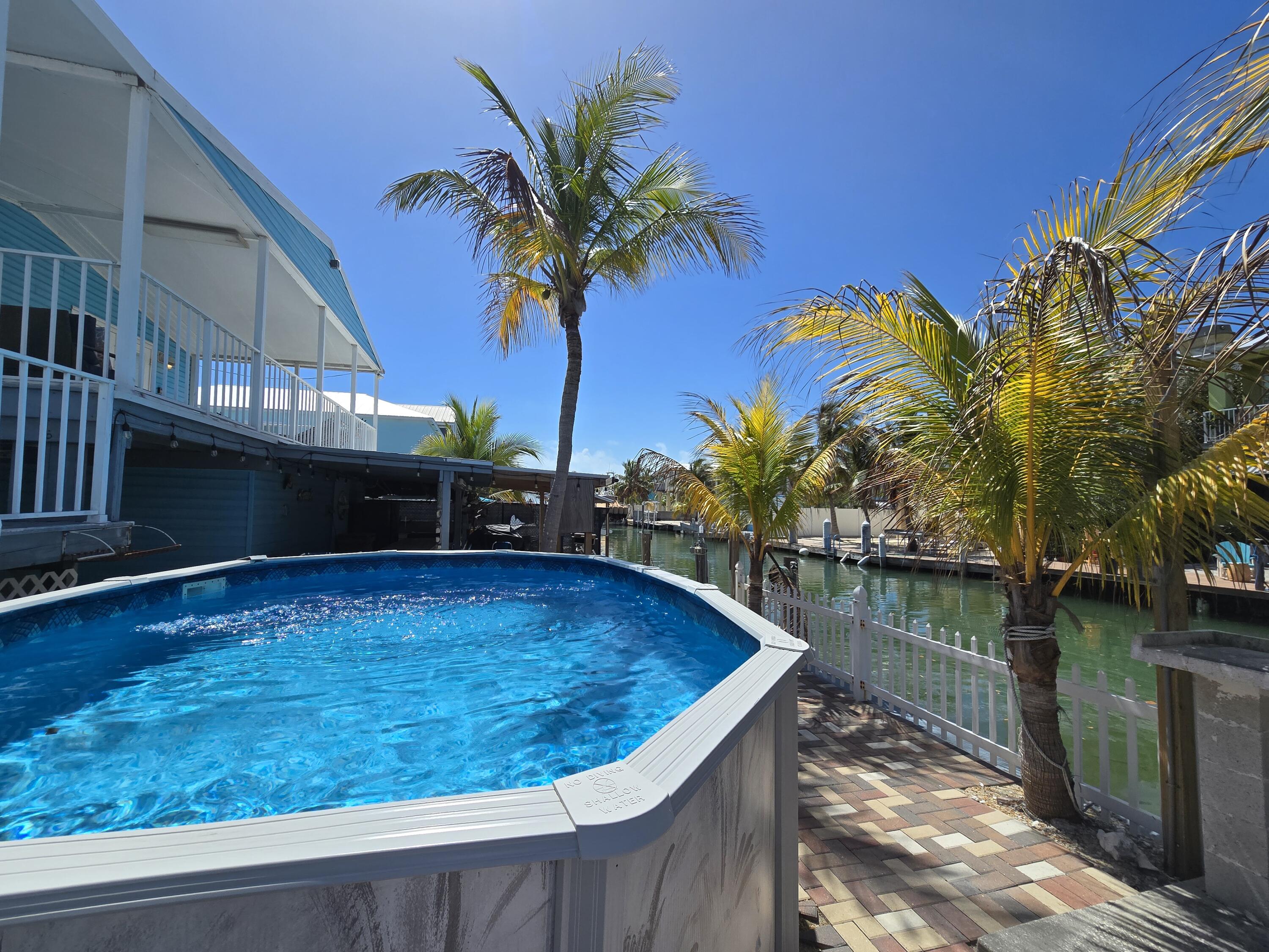 837 91st St Ocean Marathon, FL 33050 - Photo 27 of 27 a view of a swimming pool with a table and chairs