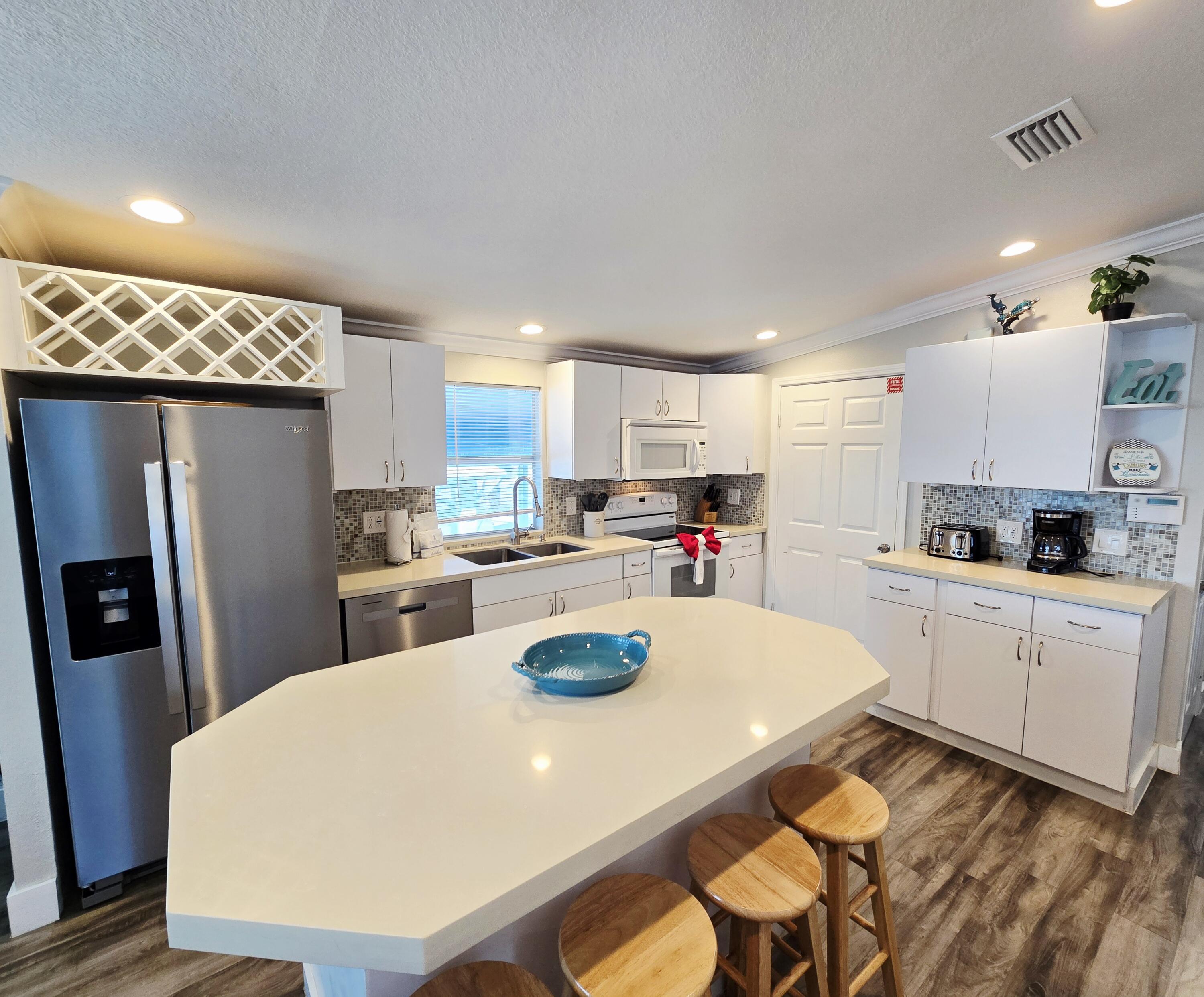 837 91st St Ocean Marathon, FL 33050 - Photo 8 of 27 a kitchen with stainless steel appliances a dining table chairs refrigerator and sink