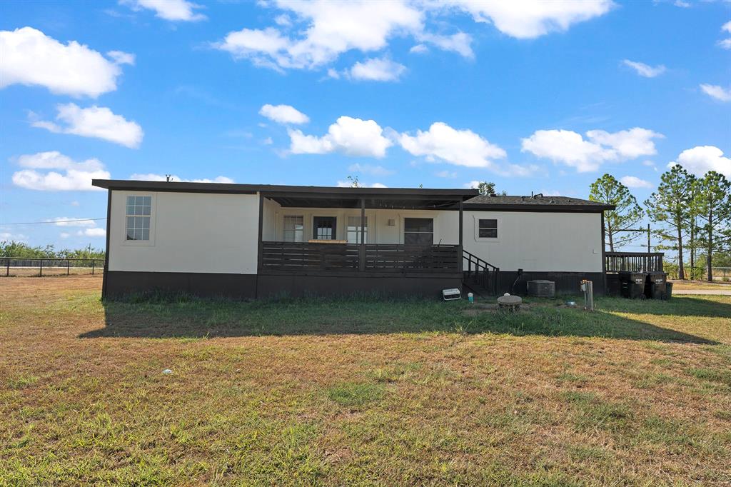 1222 Anglin Way Terrell, TX 75161 - Photo 23 of 26 Rear exterior featuring a spacious covered deck overlooking the expansive backyard—ideal for relaxing, entertaining, and enjoying the outdoors.