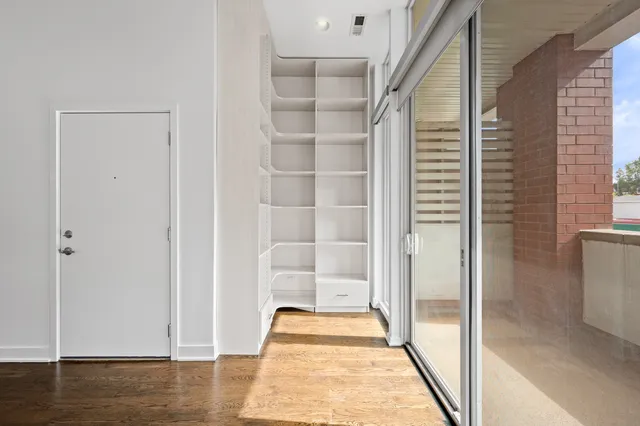 an empty room with wooden floor and entrance