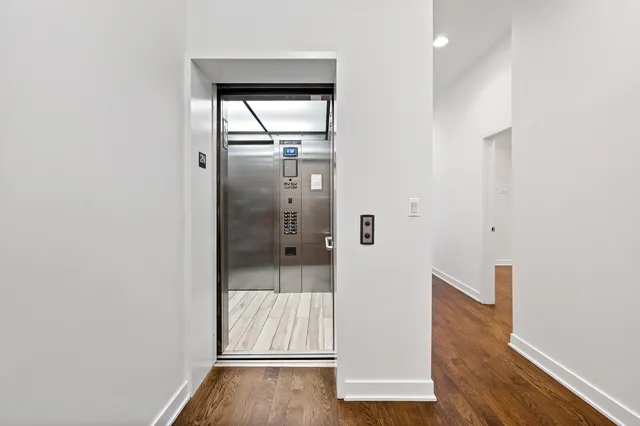 a large kitchen with stainless steel appliances granite countertop a stove a sink a refrigerator and a wooden floor