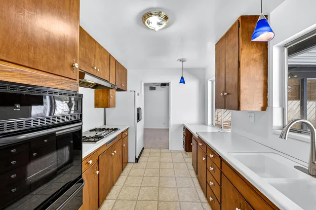 a kitchen with stainless steel appliances a stove a sink and a refrigerator