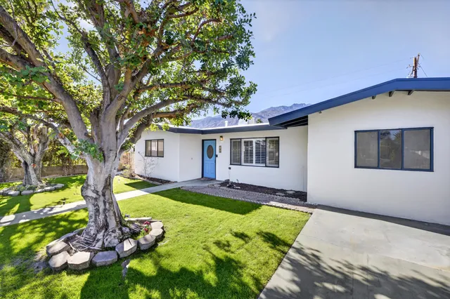 a view of a house with swimming pool and a yard