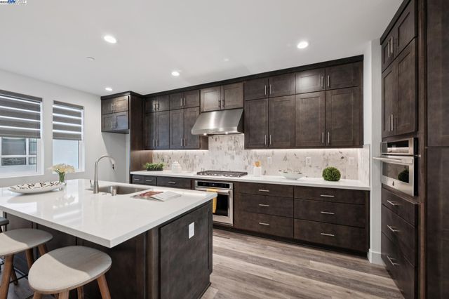 a kitchen with a sink cabinets and wooden floor