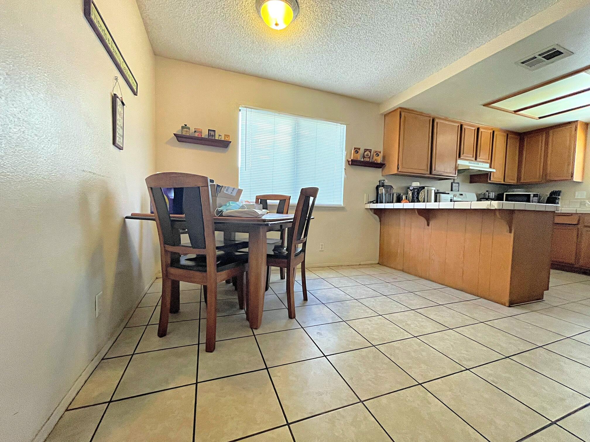 37710 Boxthorn Street Palmdale, CA 93552 - Photo 13 of 43 a kitchen with stainless steel appliances a table and chairs in it