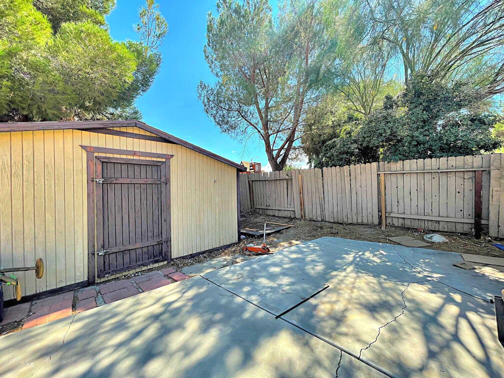 37710 Boxthorn Street Palmdale, CA 93552 - Photo 37 of 43 a backyard of a house with lawn chairs and wooden fence