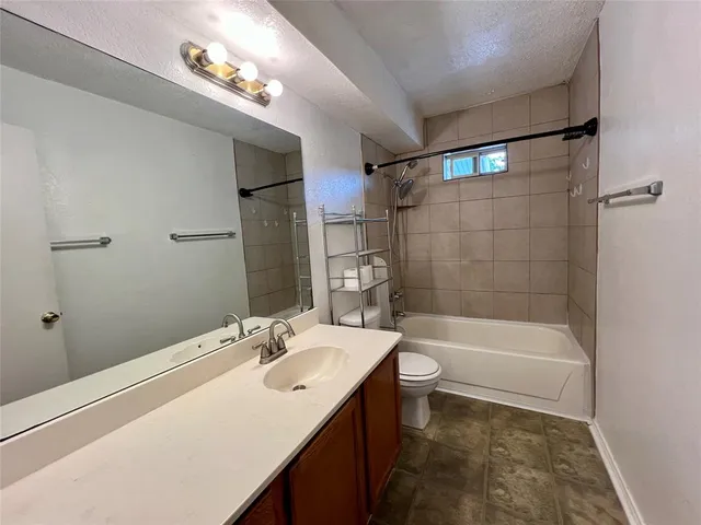 a bathroom with a tub a sink and a large mirror
