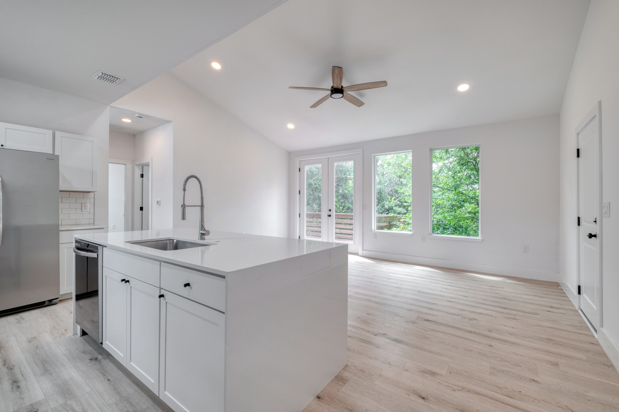 5211 Rob-Scott Street Austin, TX 78721 - Photo 5 of 24 A sleek island kitchen flows seamlessly into a bright living space with direct outdoor access.