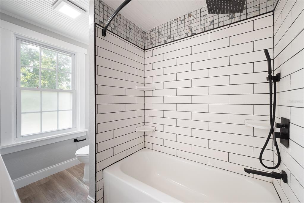 922 Delaware Avenue St. Cloud, FL 34769 - Photo 20 of 31 a bathroom with a white bathtub and a shower