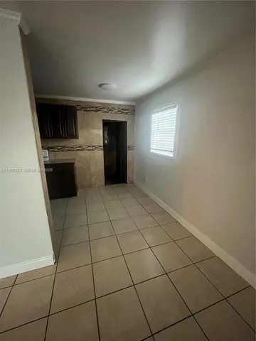 a view of an empty room and kitchen