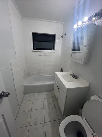 a view of an empty room and chandelier fan