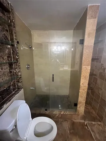 a bathroom with a toilet and a shower