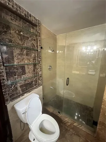 a bathroom with a shower a toilet and a sink
