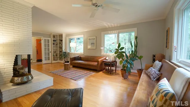 a living room with furniture floor to ceiling window and potted plant