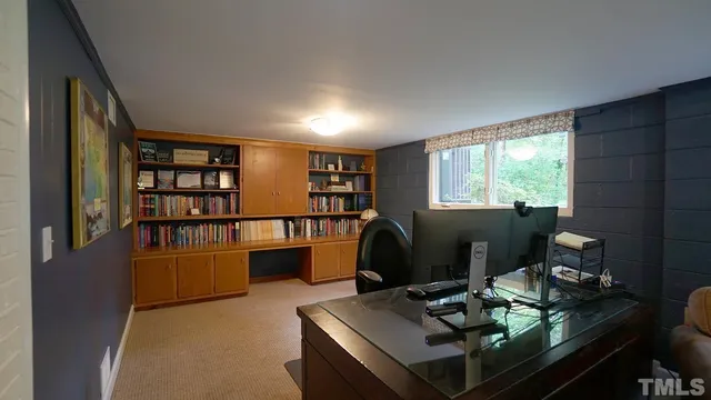 a view of a workspace with furniture and a bookshelf