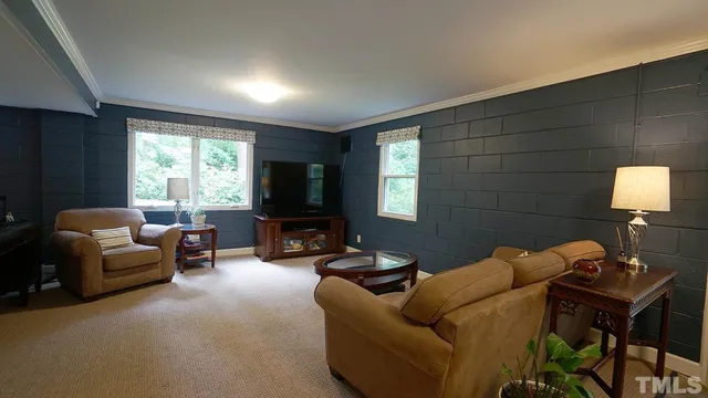a living room with furniture a flat screen tv and a window