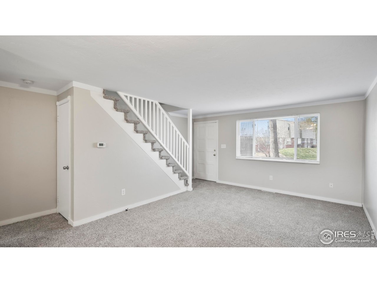 215 Chestnut Street, Unit A5 Windsor, CO 80550 - Photo 3 of 18 a open hall with a floor to ceiling window and stairs