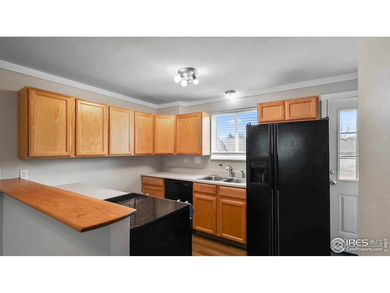 215 Chestnut Street, Unit A5 Windsor, CO 80550 - Photo 7 of 18 a kitchen with a refrigerator a sink and cabinets