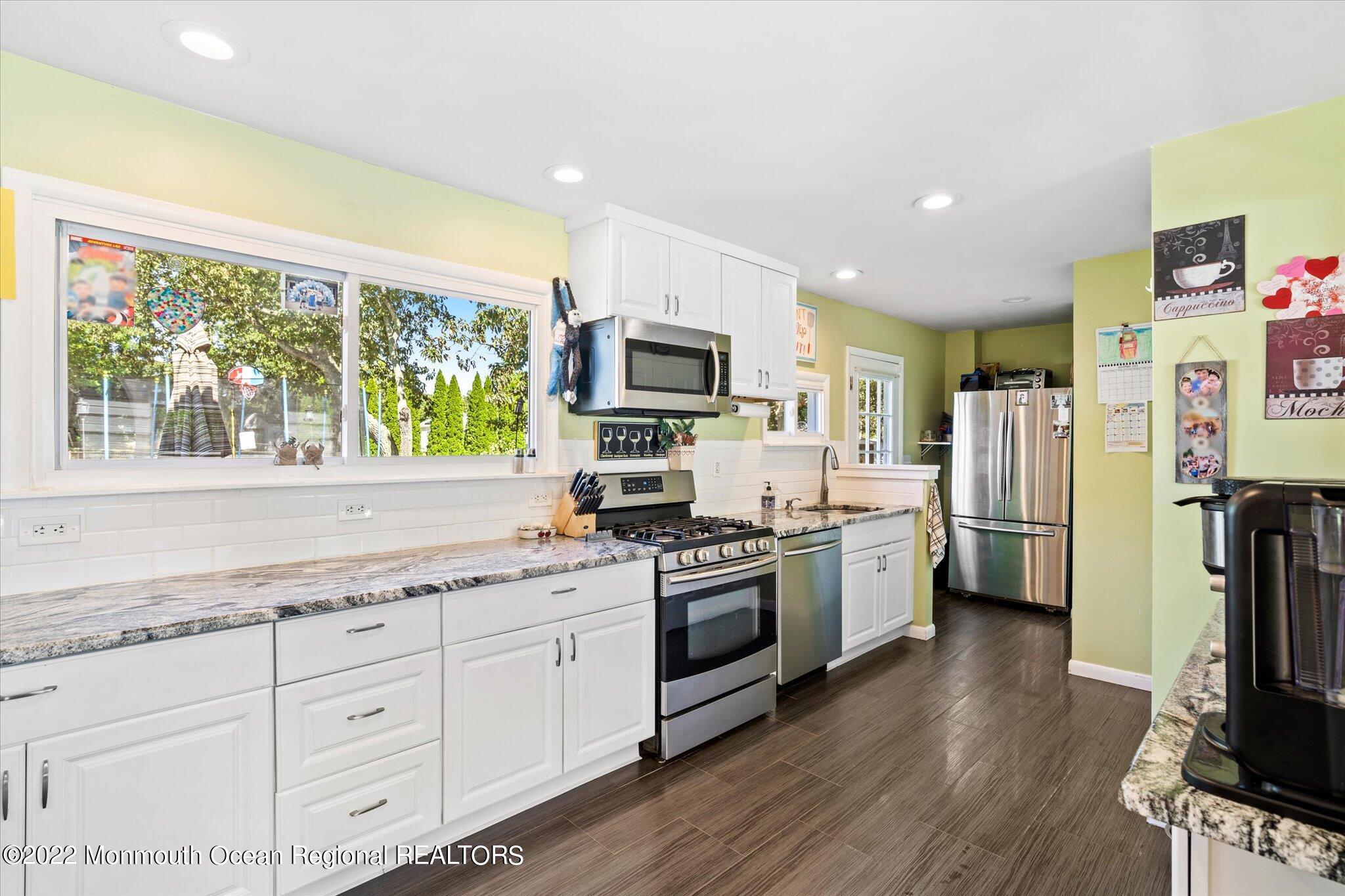 2 Sunset Drive Howell, NJ 07731 - Photo 41 of 41 a kitchen with granite countertop a stove top oven a refrigerator and a sink with wooden floor