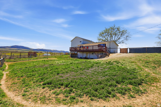 830 North Stone Road Snowville, UT 84336 - Photo 63 of 69 Back of house featuring a fenced backyard, a deck with mountain view, and a rural view